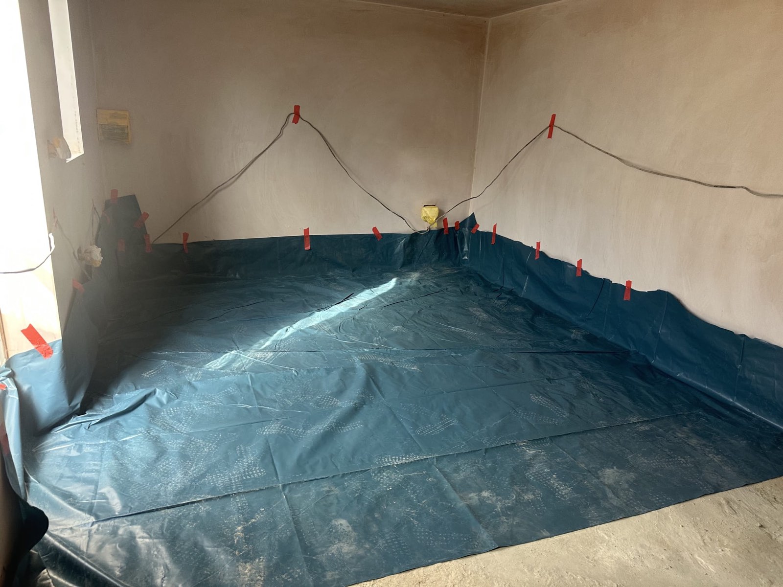 Damp proof membrane fitted and taped up the walls of a garage conversion