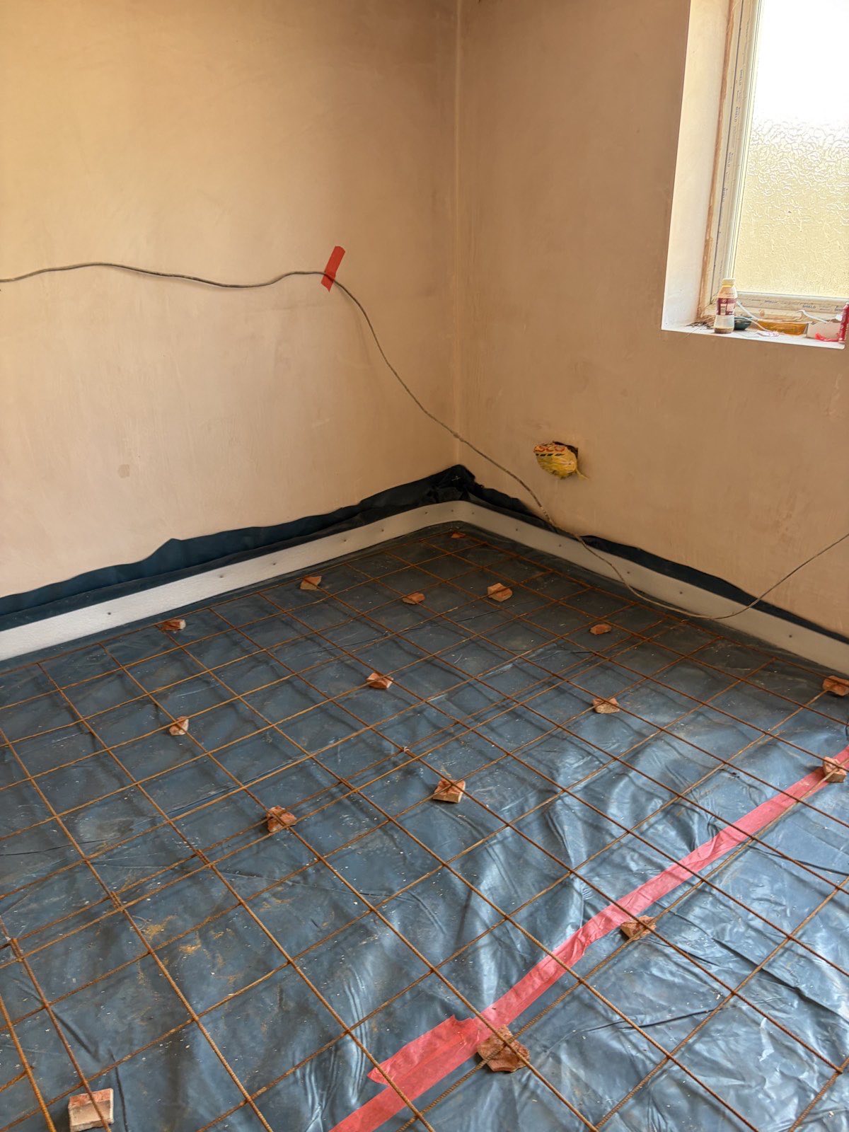 Reinforcement mesh and perimeter edge strip before screeding a garage conversion floor