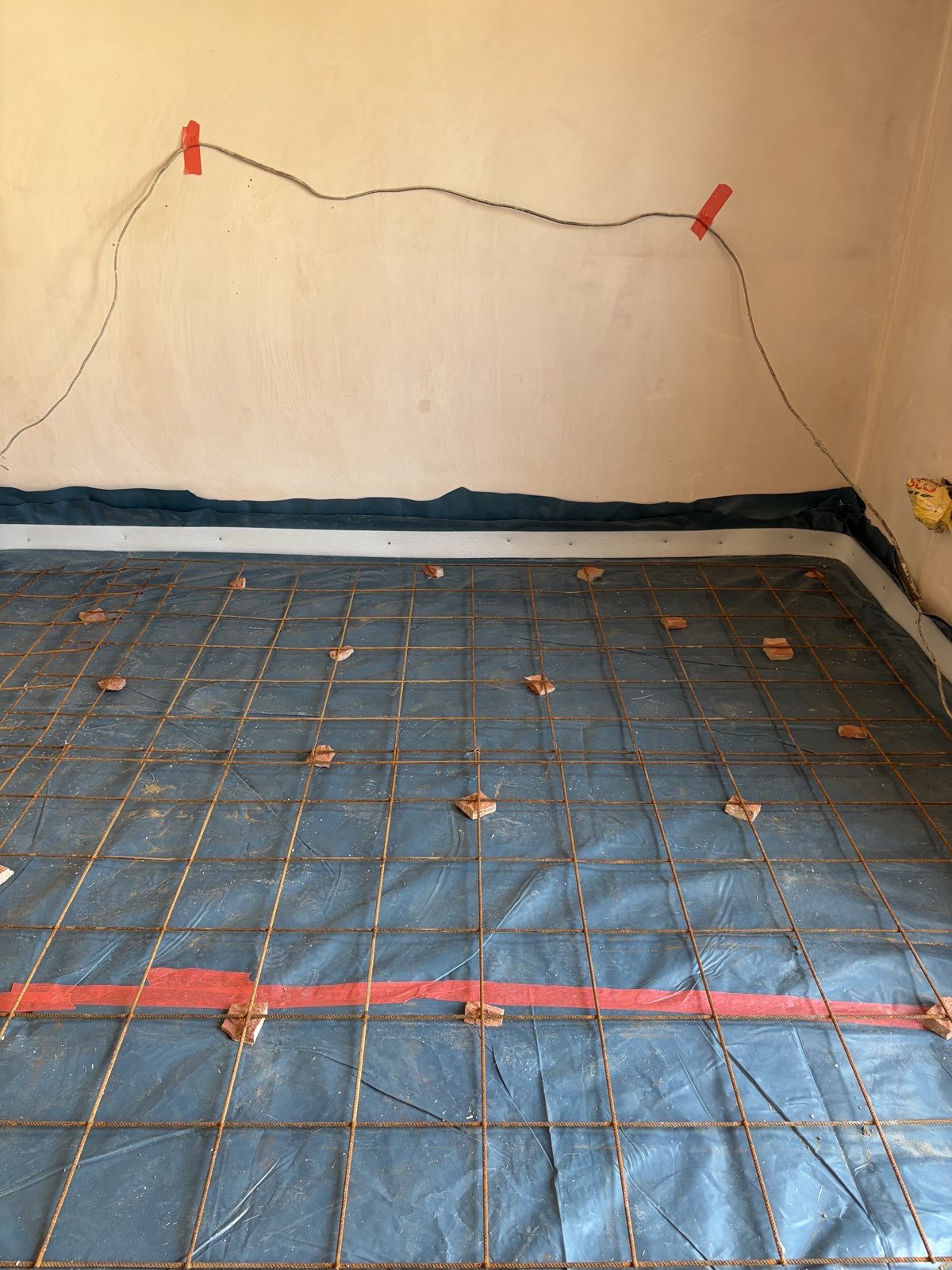 Reinforcement mesh on spacers over a damp proof membrane in a garage conversion floor